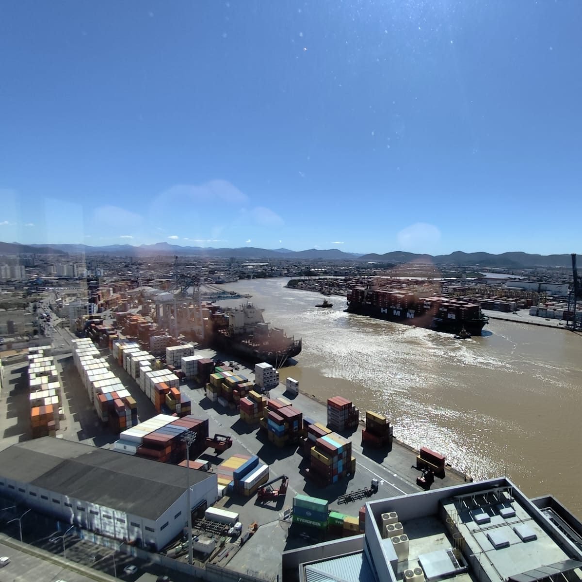 Complexo portuário de Itajaí e Navegantes, com pátio de contêineres e um navio manobrando no rio Itajaí-Açu