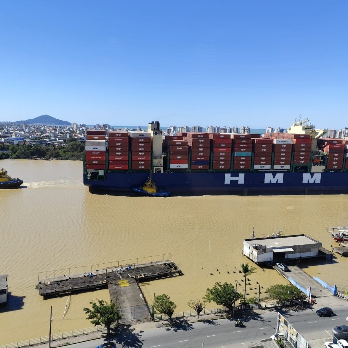 Container ship with two tugboats on the Itajaí river, in Itajaí, Brazil